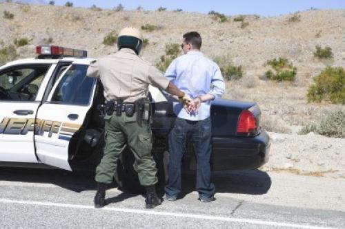 12513805-police-officer-arrests-male-driver
