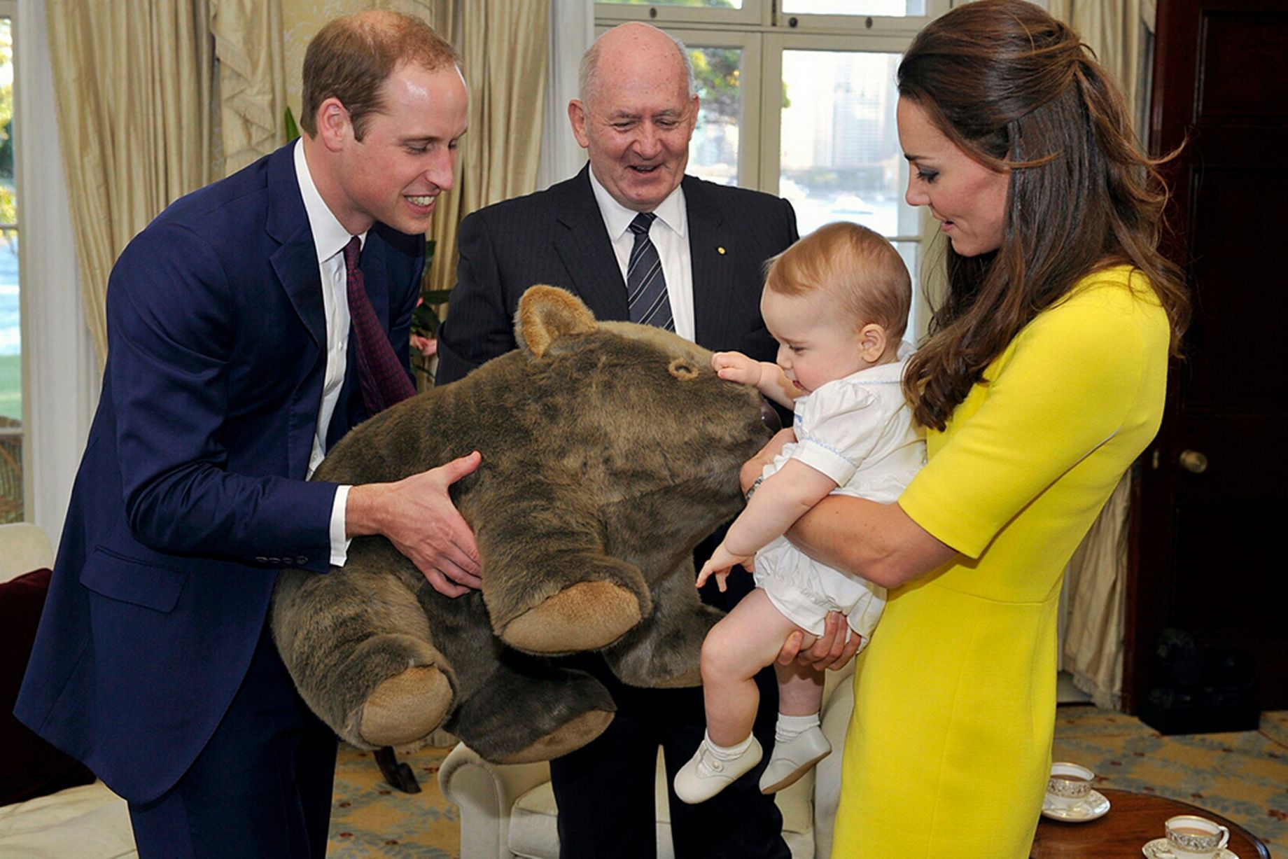 Catherine-Duchess-of-Cambridgeand-Prince-William-Duke-of-Cambridge-pose-with-a-surfboard